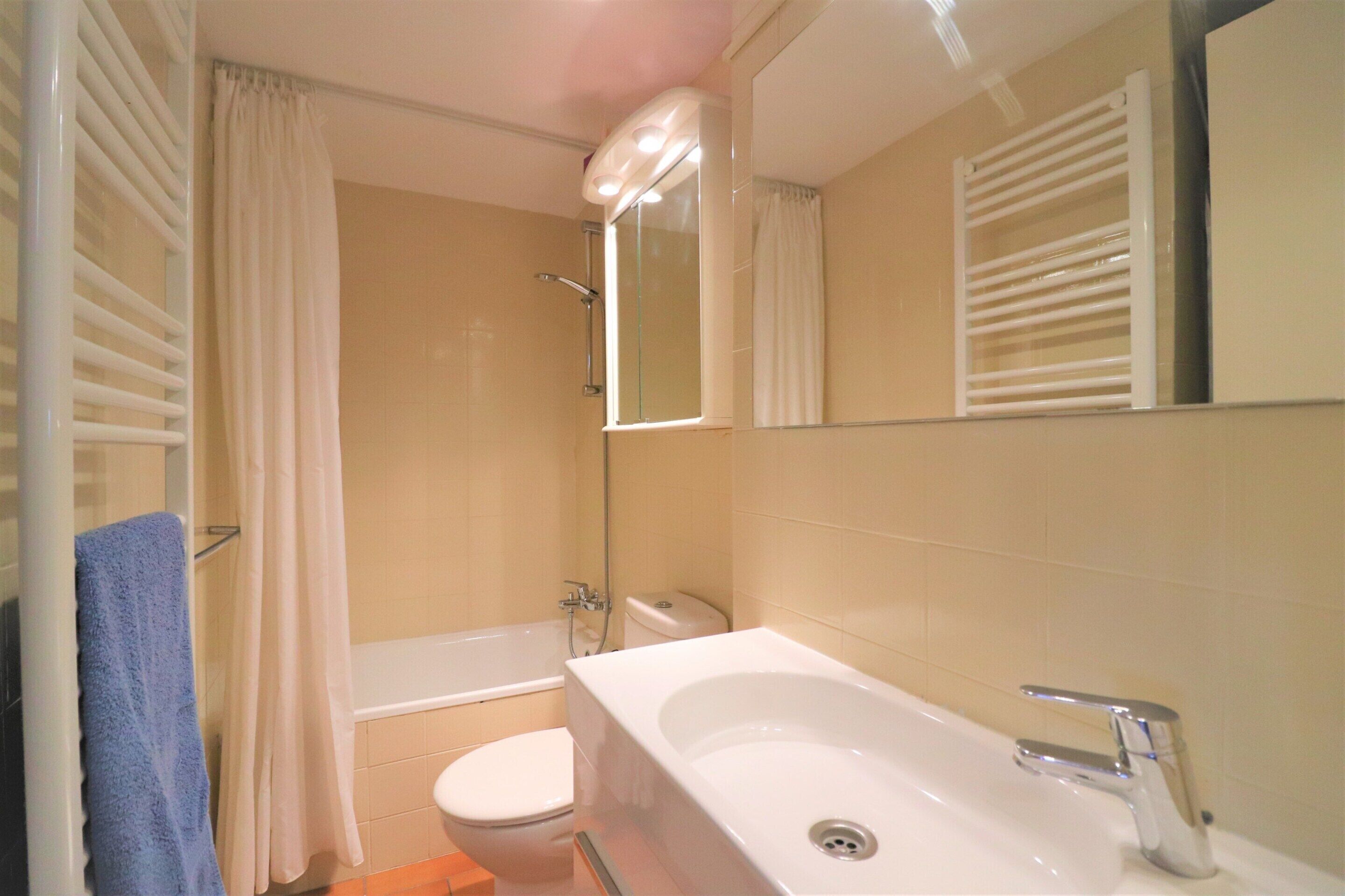 A bathroom with a bathtub, toilet, and sink.
