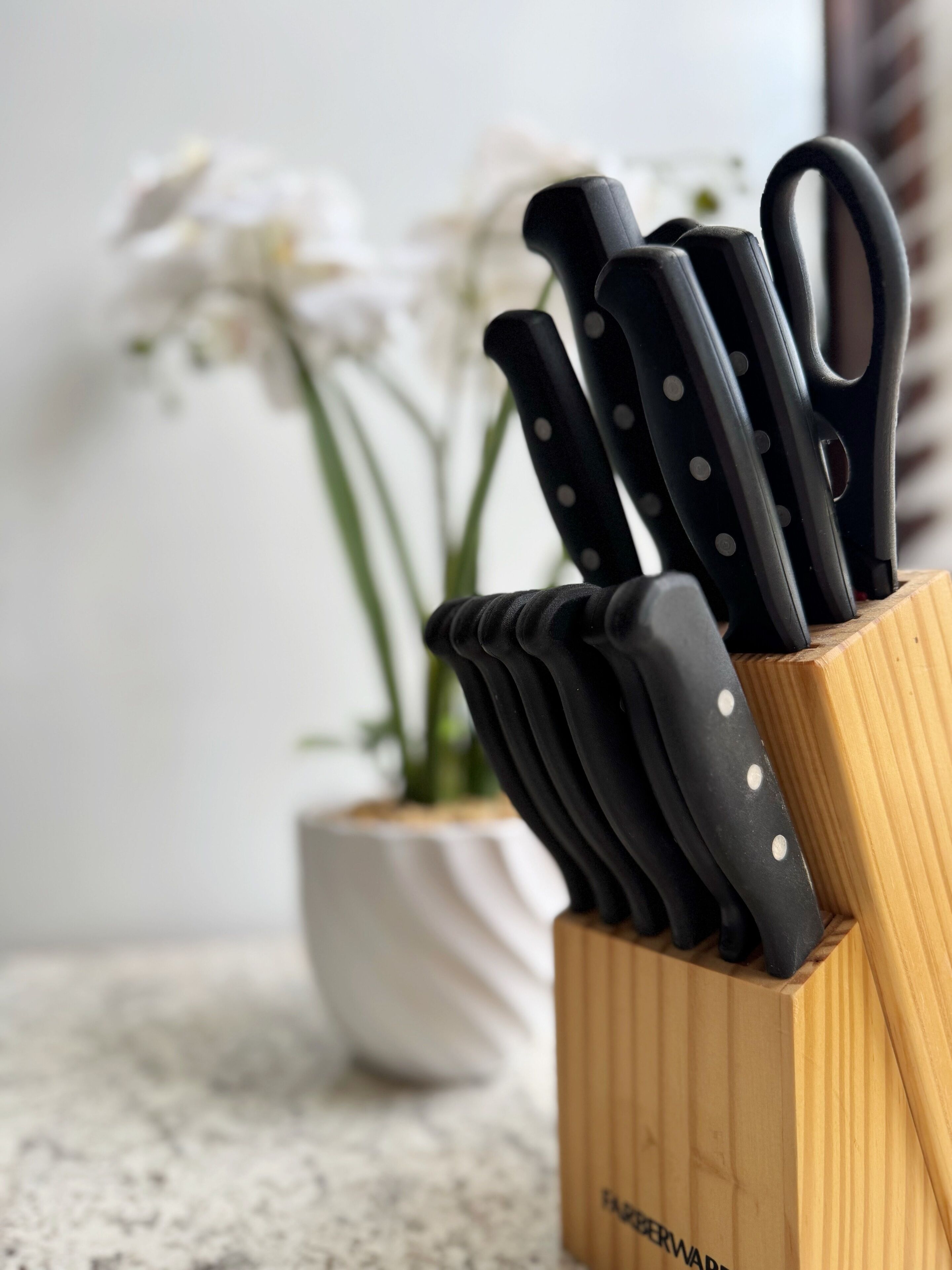 A wooden knife block with several knives.