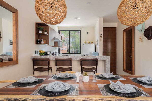 Enjoy meals in this stylish dining area with a table for four, kitchen island, and pendant lights.