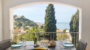 A dining table set for two with a view of the sea and hills. - Apartment in Roses Near Canyelles Beach (Roses)