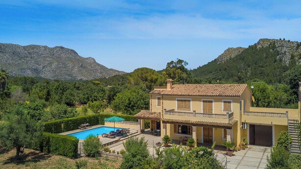 A Mediterranean-style villa with a swimming pool, surrounded by lush greenery and mountains. - Can Pansa - Three Bedroom Villa, Sleeps 6 (Pollensa)