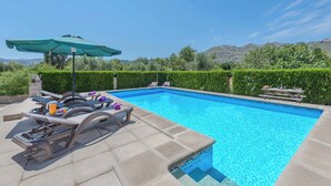 A swimming pool with lounge chairs and a picnic table, surrounded by neatly trimmed hedges and a mountain backdrop. - Can Pansa - Three Bedroom Villa, Sleeps 6 (Pollensa)