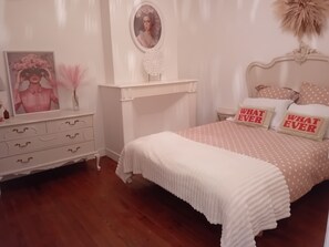 A bedroom with a white bed, a dresser, a vanity, and a mirror. - Charming triplex apartment of 80 m2,  (Carbonne)