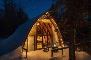 A cozy cabin with a sloped roof, large windows, and a fire pit outside. - Retro A-Frame w/ Hot Tub, Perfect Couple's Getaway (Island Park)