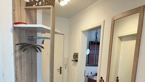 Un baño con tocador de madera, un espejo y zona de ducha.