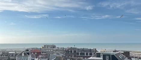 Un pueblo costero con edificios históricos, cielo despejado y vistas al mar.