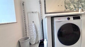 A laundry room with a washing machine, a drying rack, and a bucket. - Beautiful house in the heart of Rome 20meters from Piazza Venezia/Trevi Fountain (Roma)