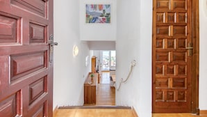 A hallway with a wooden door on the left, a wooden door on the right, and a small table with a plant in the center. - Apartment in Rosas Near Cap de Creus (Roses)