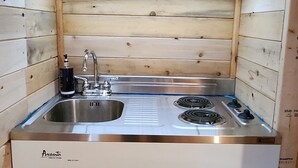 Cocina compacta con fregadero, dos hornillas y lavavajillas integrado.