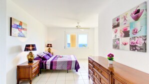 A bedroom with a bed, bedside tables, a dresser, and a large floral artwork on the wall. - Apartment in Roses Near Sand Beach (Roses)