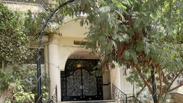 A set of stone steps leading to a gated entrance with a wrought iron railing. - Kemt pyrimds view  (Giza)