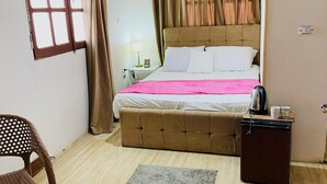 A bedroom with a bed, a chair, a small table, a kettle, and a refrigerator. - Kemt pyrimds view  (Giza)
