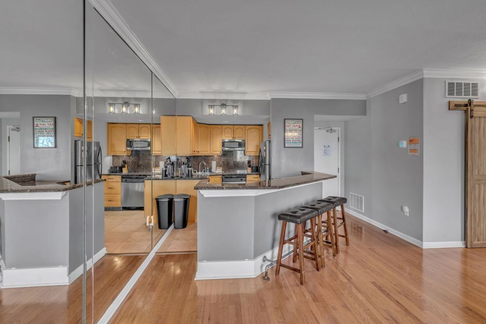 Una cocina moderna con armarios de madera, una isla central y un panel de vidrio.