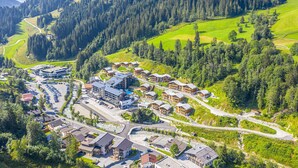 A residential area with a mix of single and multi-story houses, a central building with a parking lot, and a road network. - Chalet in Wagrain Near the Flying Mozart (Wagrain)