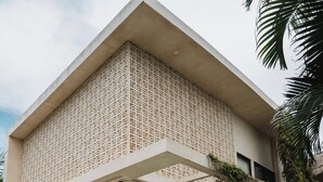 A modern building with a pool, outdoor seating, and greenery. - Ik Casa Del Viento  (Chetumal)