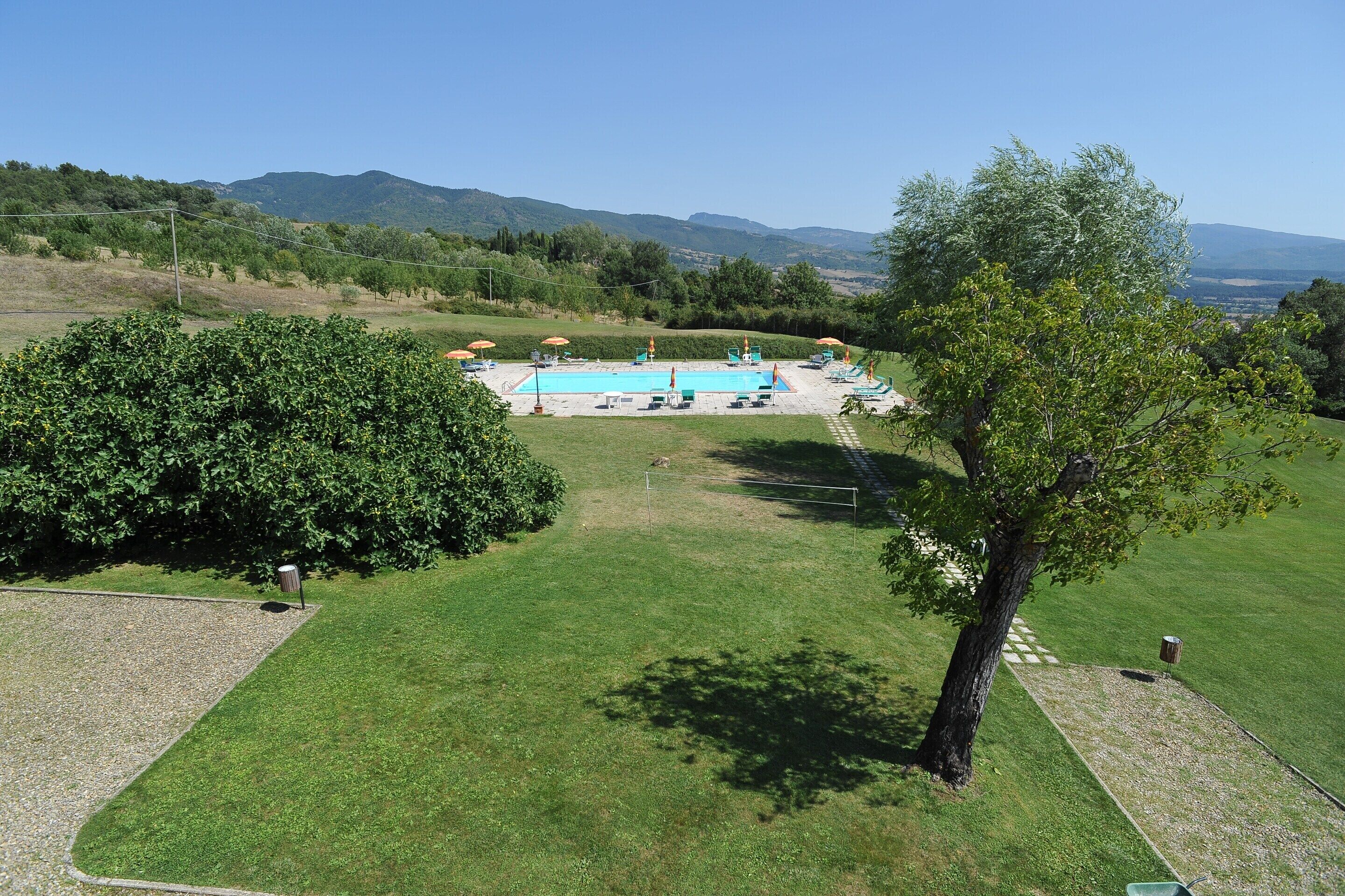 A pool area with a clear view of the surrounding landscape, including hills and trees.