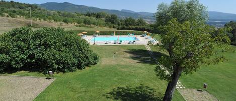 A pool area with a clear view of the surrounding landscape, including hills and trees.
