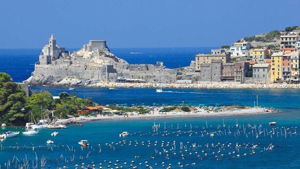 A coastal town with historic stone buildings, a marina with boats, and a beach area. - Residence with pool in Luni Mare (Luni)