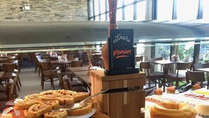 Een buffet met diverse gebakjes, broodjes en een chocoladetaart.