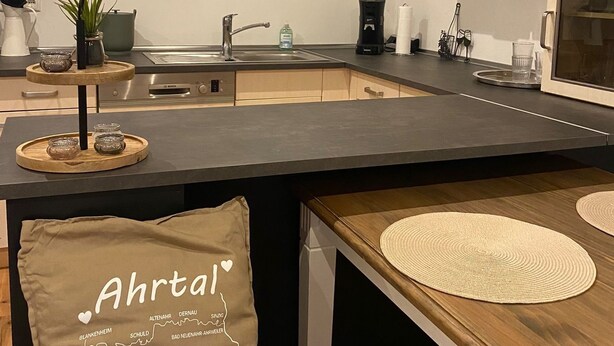Una cocina moderna con una isla central, encimeras de madera y muebles de cocina minimalistas.