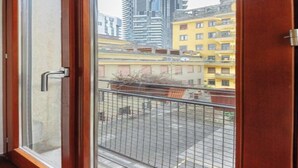 A view from a balcony with a metal railing, overlooking a cityscape with various buildings, including a tall skyscraper and residential buildings. - Modern Apartment in Porta Nuova, Milan

 (Milano)