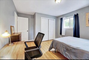 Cozy retreat with a single bed, desk, and wardrobe.