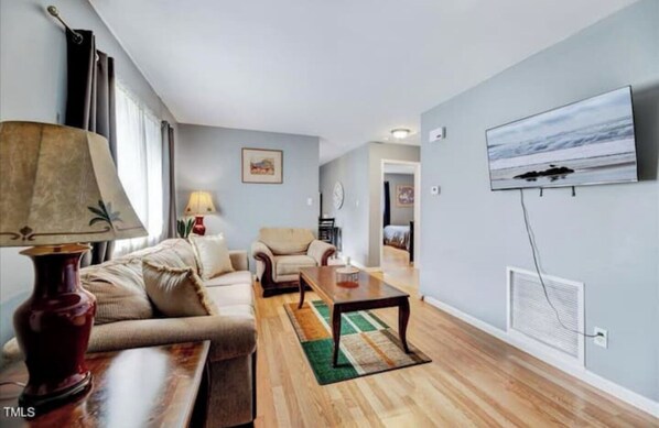 Relax in this stylish living room with a sofa set, coffee table, and mounted TV.