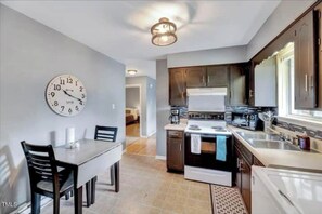 Enjoy meals in the kitchen with a central island and dining area featuring a table and chairs.