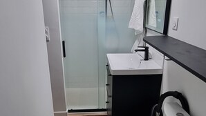 A modern bathroom with a toilet, sink, and shower.