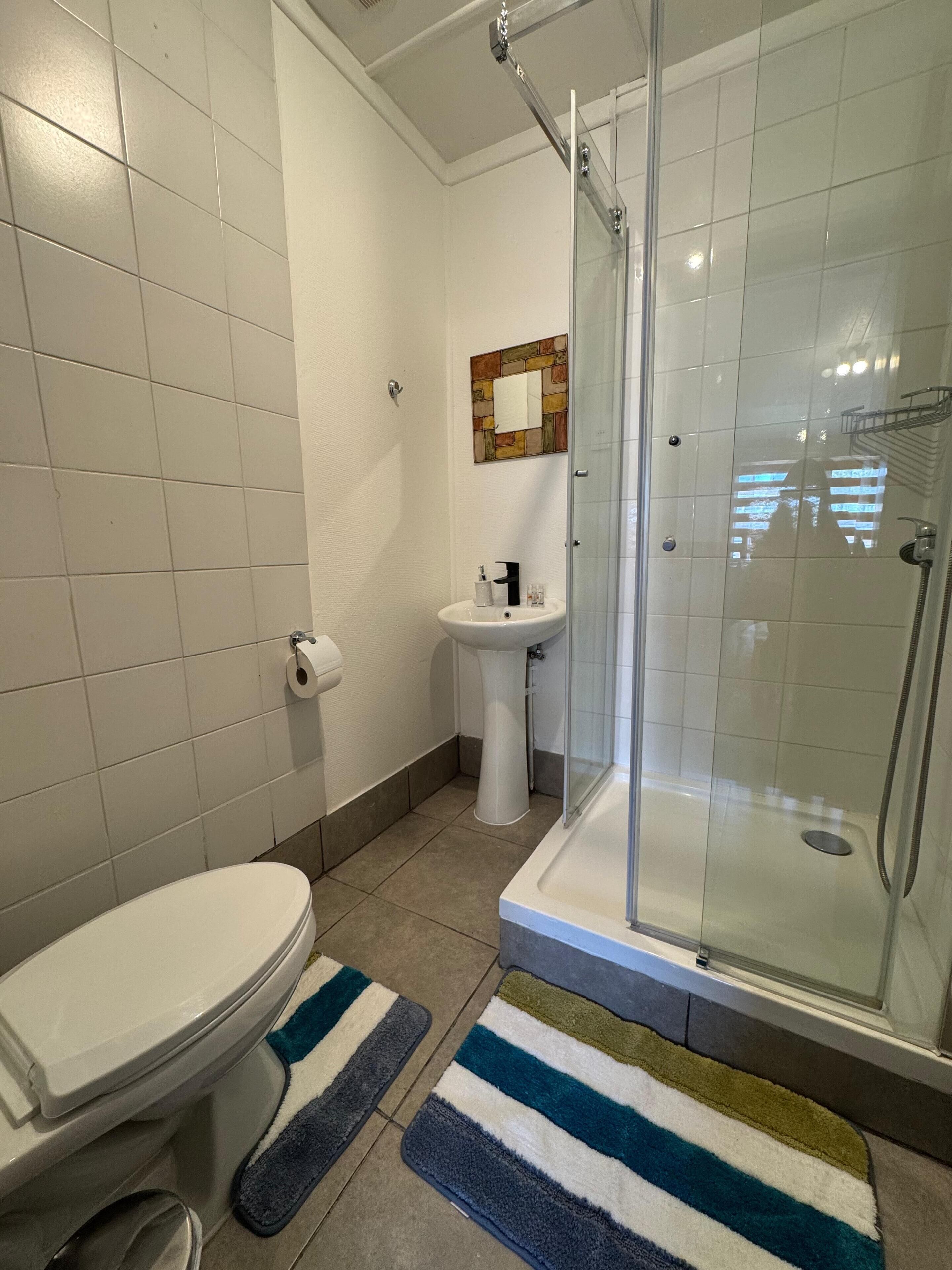 Ein Badezimmer mit Toilette, Waschbecken und Duschkabine.