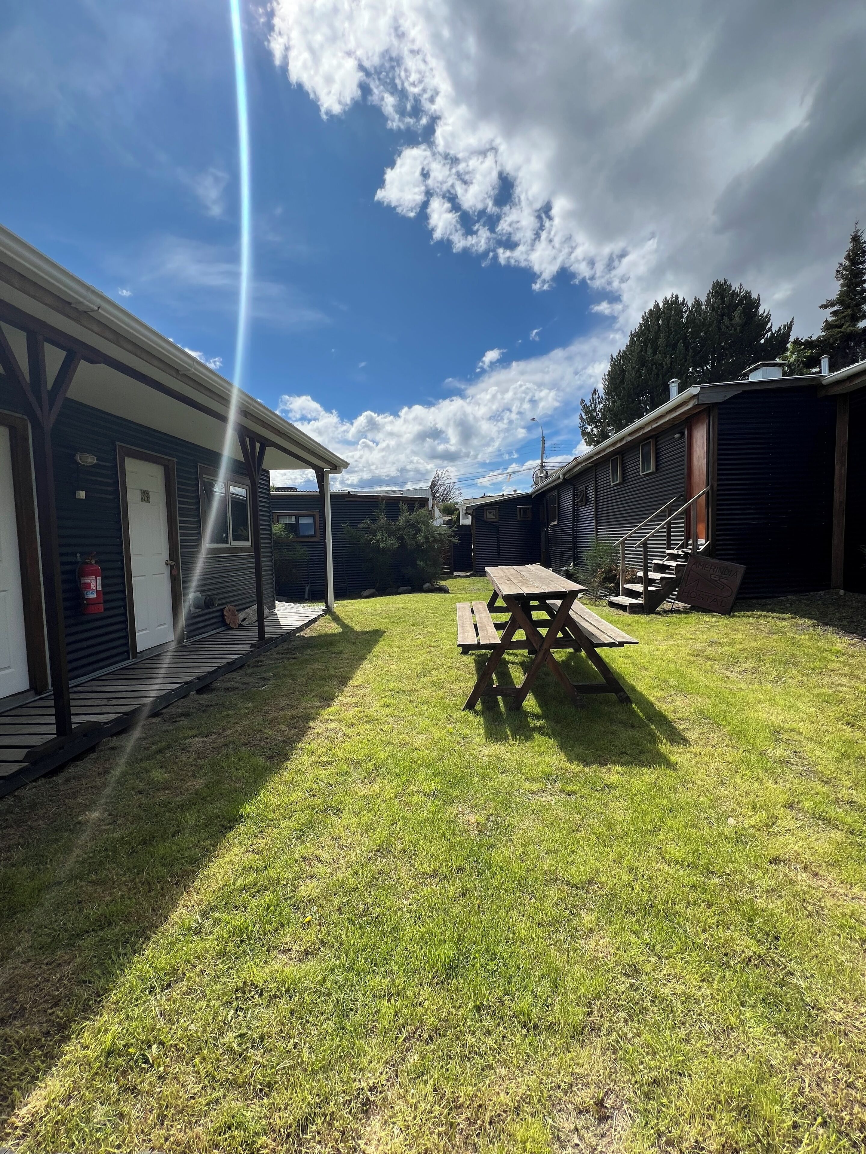 A grassy area with a picnic table and a building with a covered porch.