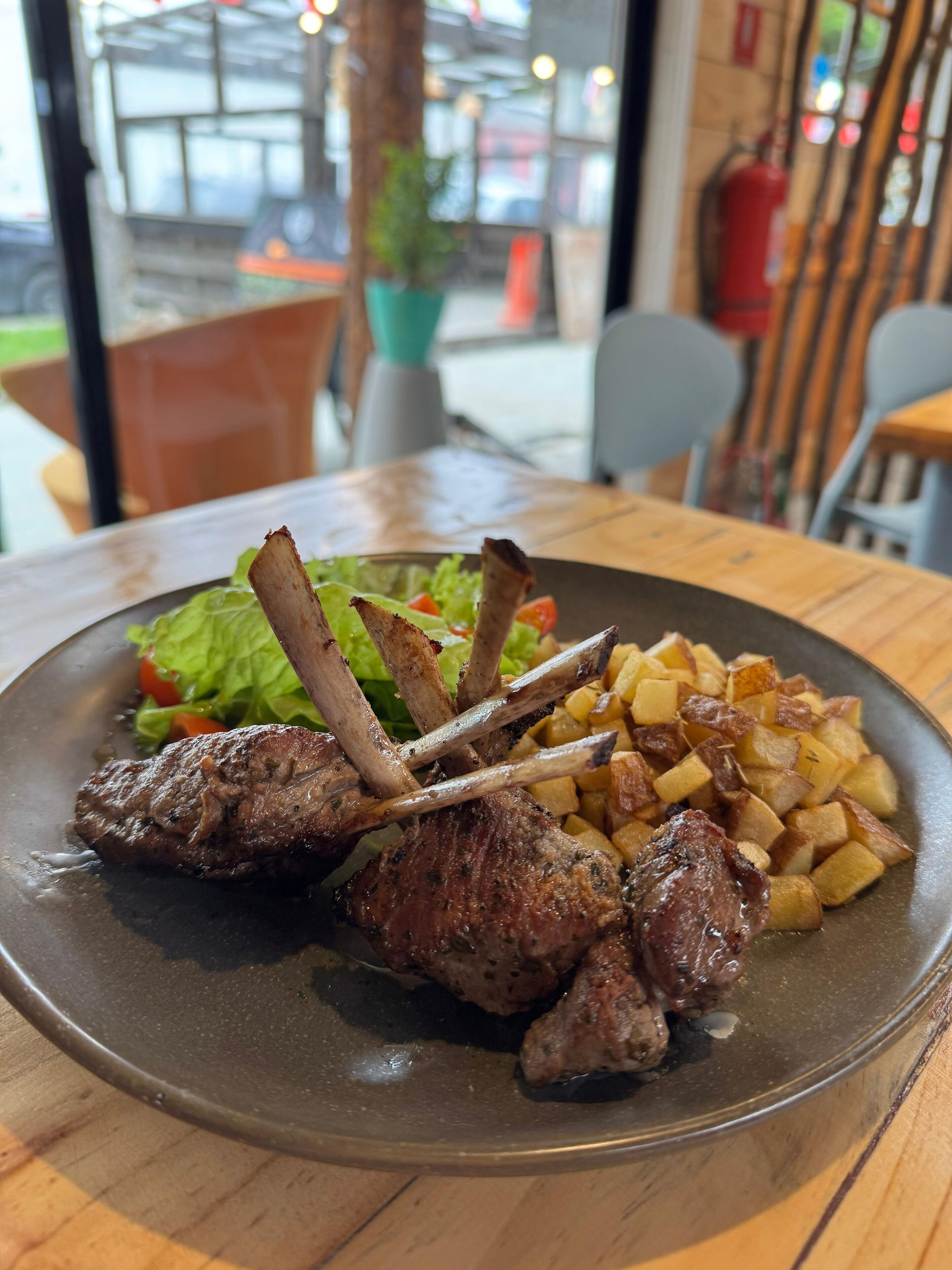 A plate with grilled meat, potatoes, and salad.