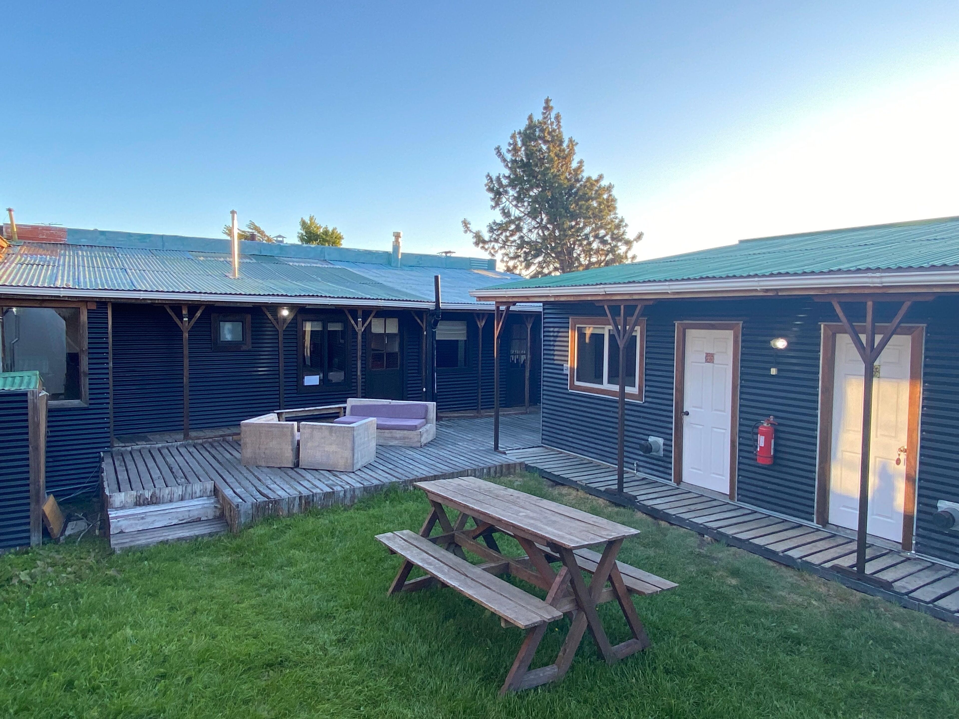 A rustic cabin-style building with a wooden deck and picnic table.