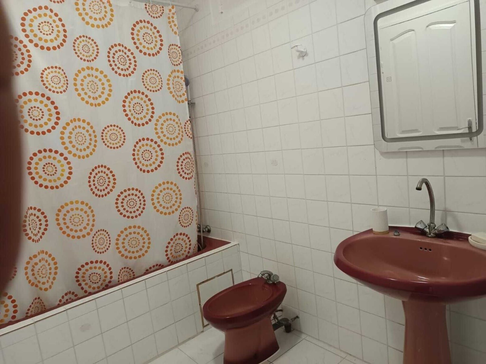 Une salle de bain équipée de toilettes, d’un bidet et d’un lavabo.