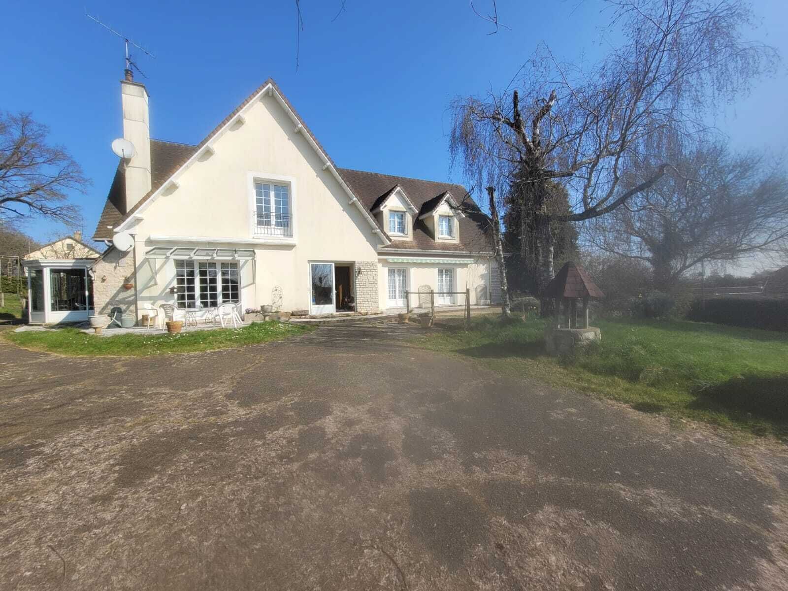 Ein zweistöckiges Haus mit großer Veranda, Satellitenschüssel und kleiner Gartenhütte.