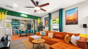 Un salon moderne avec un canapé, une table basse ronde et un ventilateur de plafond.