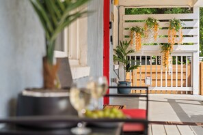 A balcony with hanging plants, a potted plant, and a wine glass on a table. - E-Bikes, Arcade Room, Fire Pit, Projector - DT ATL (Atlanta)