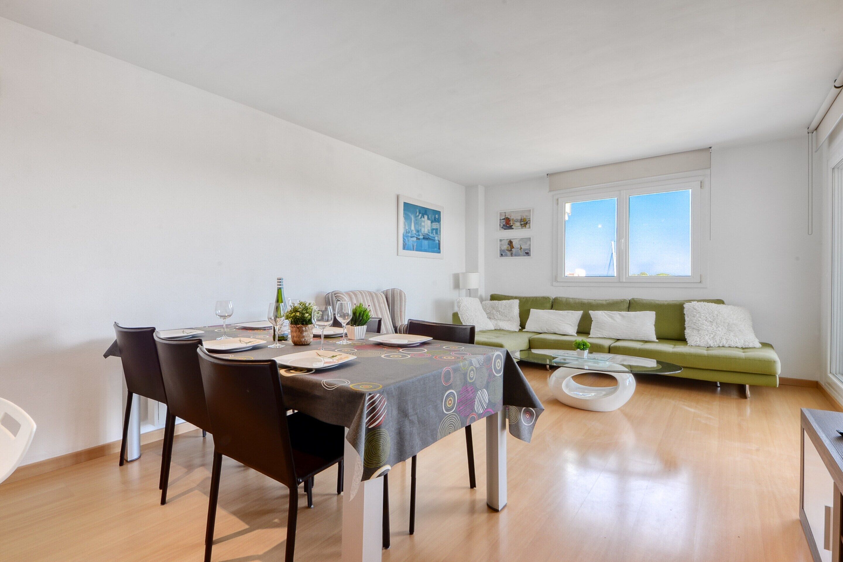 Una sala de estar moderna con una mesa de comedor, sillas, un sofá y una mesa de centro.