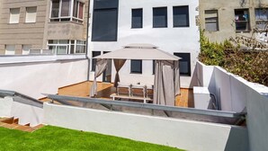 A modern apartment building with multiple floors, balconies, and a rooftop terrace with a white umbrella. - Urbanfive 1A Ourense center 3 rooms with terrace (Ourense)