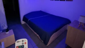 A bedroom with a bed, a nightstand, a lamp, and a wall with four pictures.
