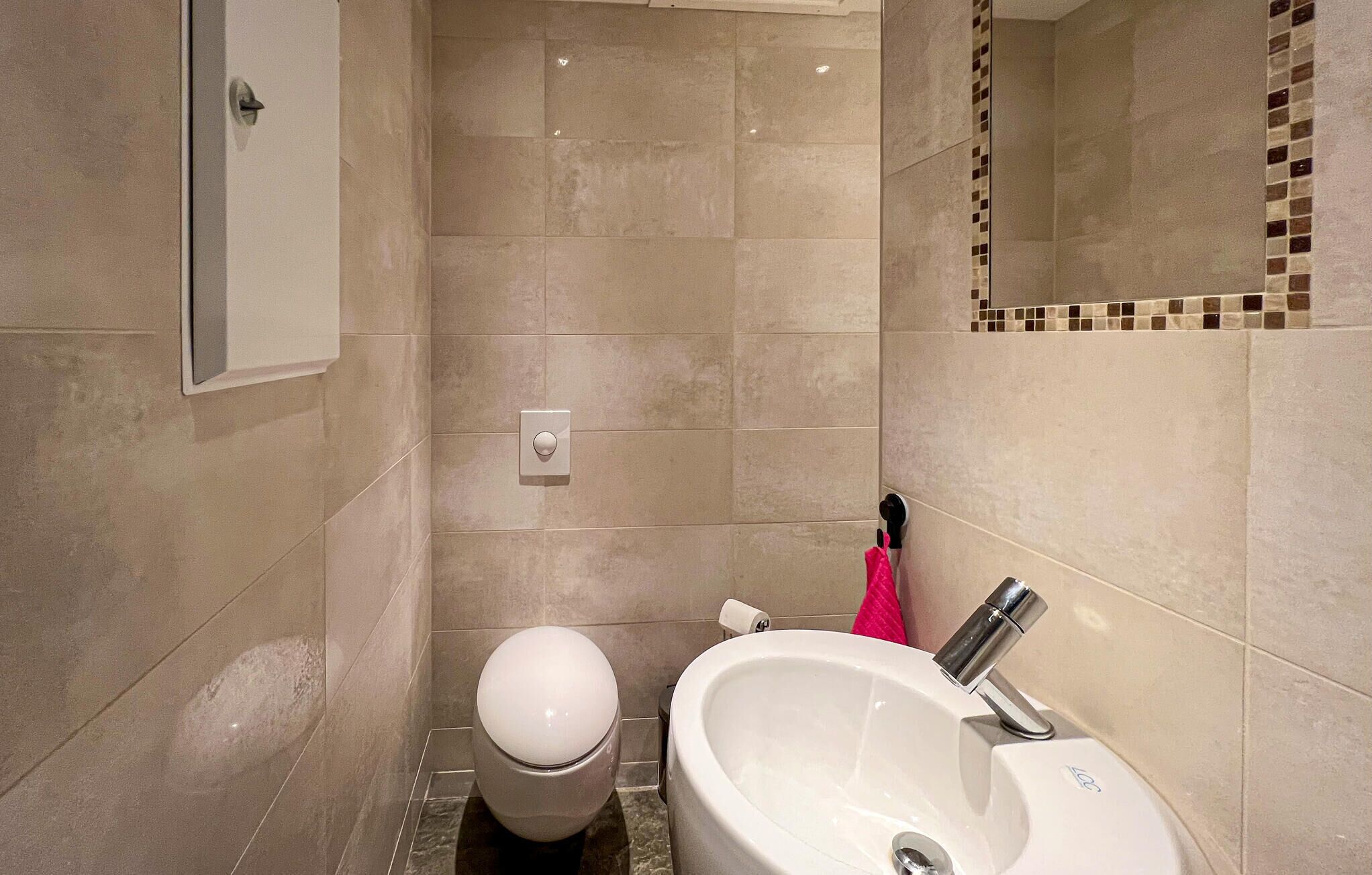 Ein Badezimmer mit Toilette, Waschbecken und Spiegel.