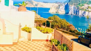 A coastal property with a view of the sea, a staircase leading to a terrace, and a parked car. - Ponzamania Siren (Le Forna)