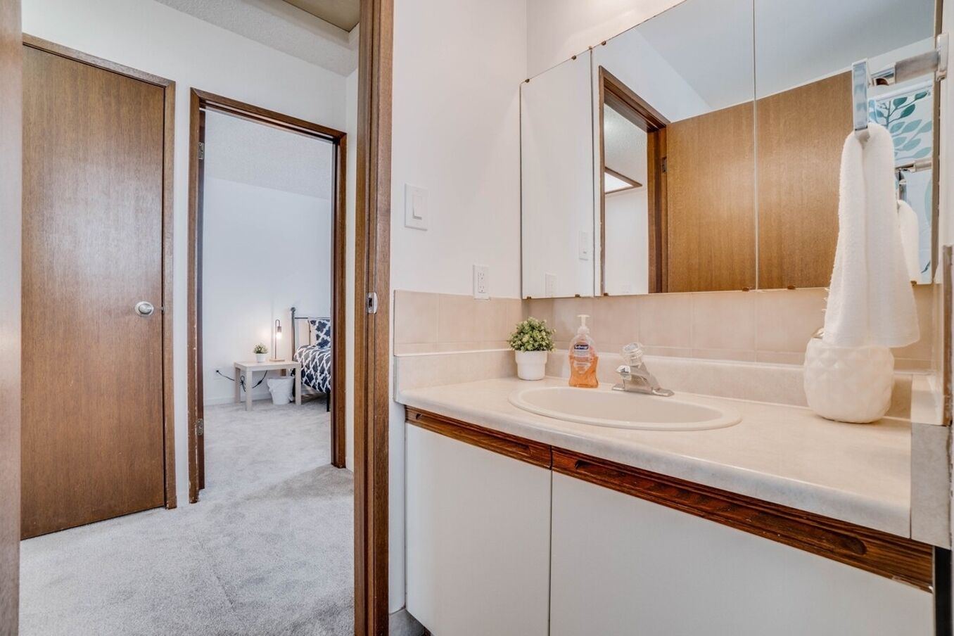 Une salle de bain moderne avec un grand miroir, un lavabo et une serviette accrochée au mur.
