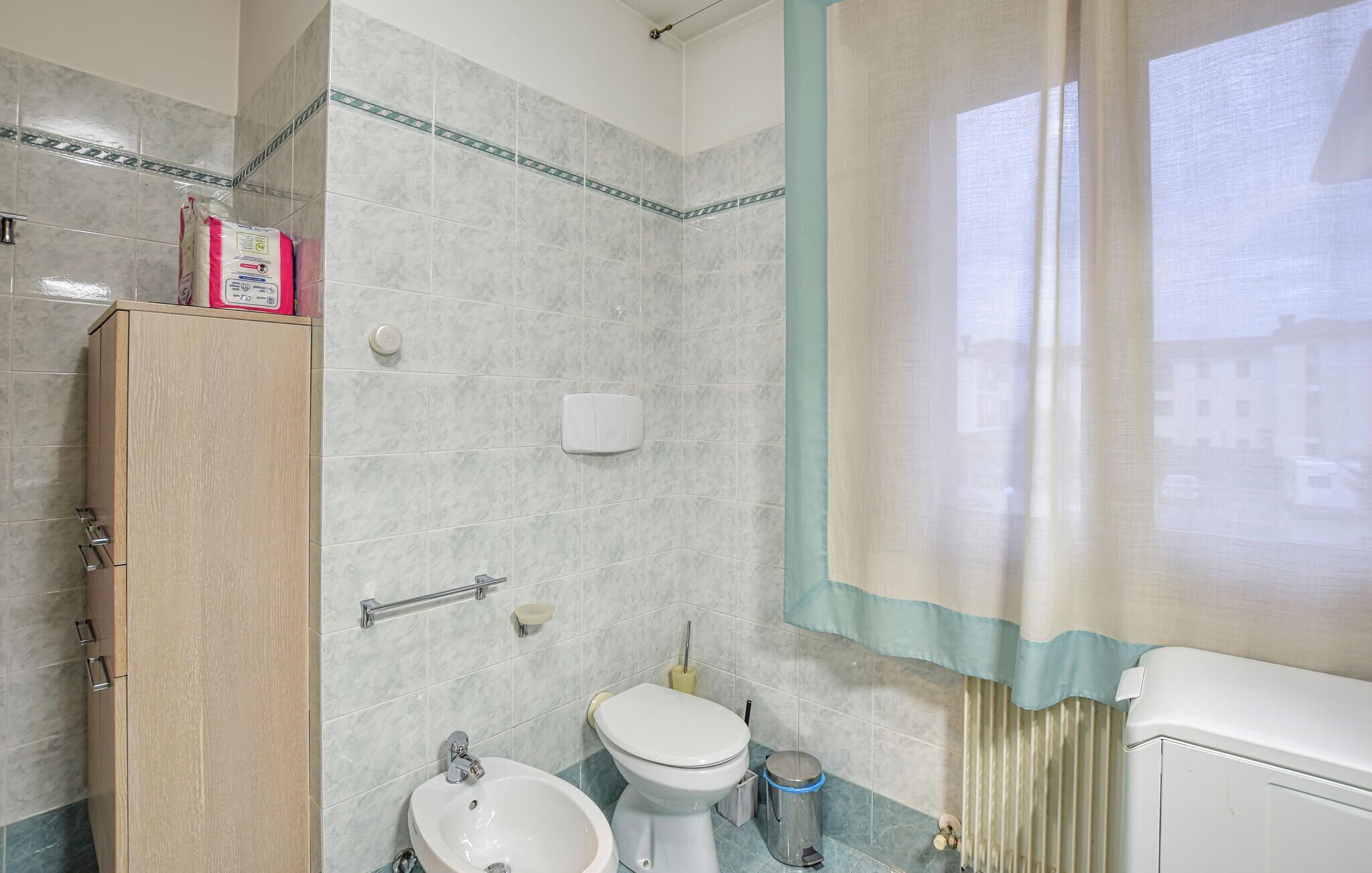 Une salle de bain comprenant des toilettes, un lavabo et un espace douche.