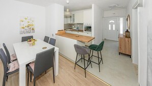 A modern kitchen with white cabinets, a wooden countertop, and a built-in oven. - Cozy home in Bobovisca (Bobovisca)