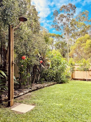 A well-maintained garden with a variety of plants and a wooden fence. - Agnes Break - Sauna, Surfboards, Walk To Beach (Agnes Water)