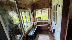 Une pièce chaleureuse aux murs en bois, avec un banc placé près de la fenêtre.