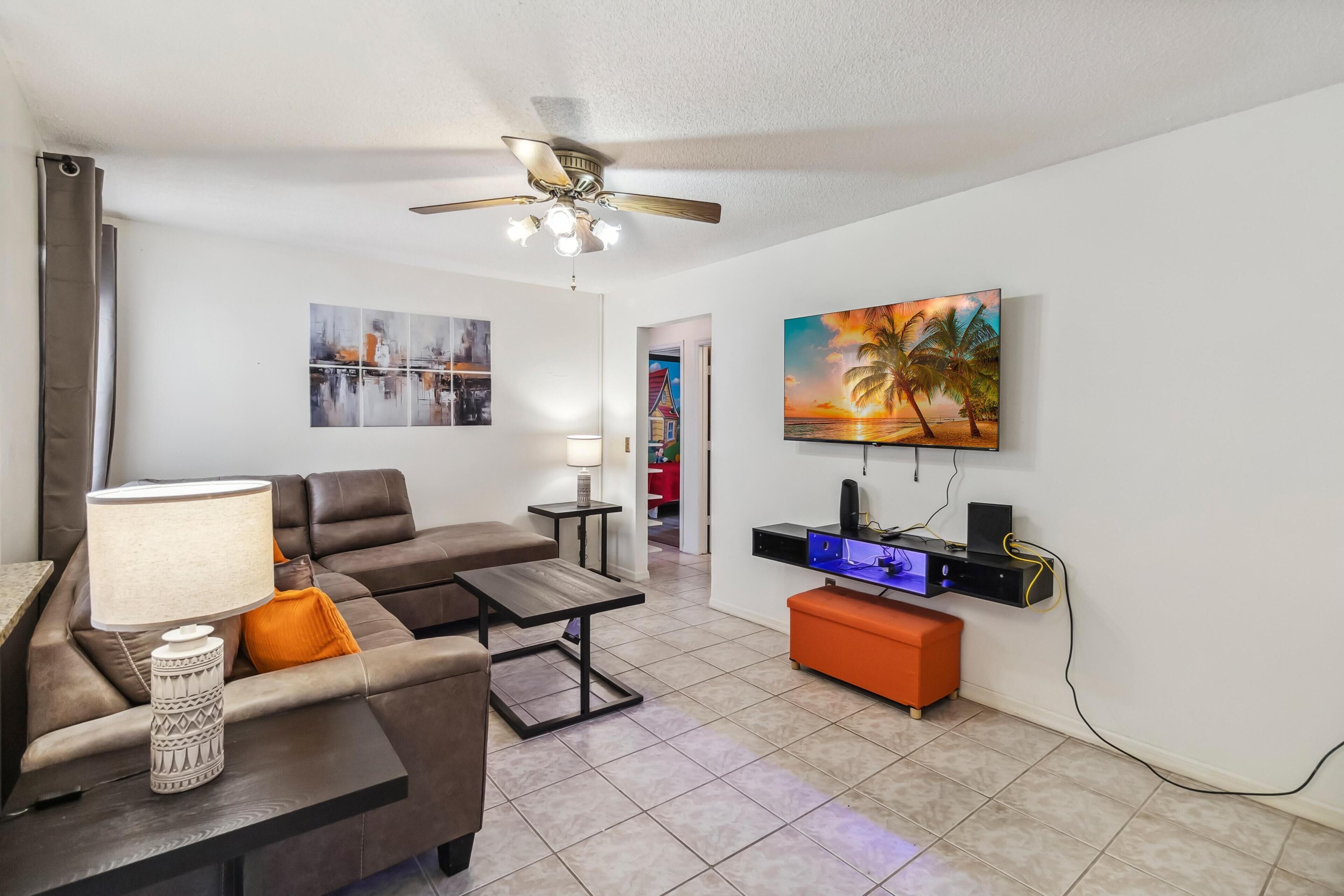 A modern living room with a sofa, coffee table, and a TV mounted on the wall.