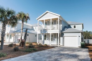 A two-story house with a covered porch and a garage. - Enclave at Lyndell Lane by Avantstay Private Pool (Panama City Beach)