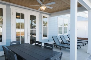 A covered patio with a table and chairs, a ceiling fan, and a view of the backyard. - Enclave at Lyndell Lane by Avantstay Private Pool (Panama City Beach)
